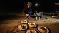 Salah satu pekerja kamp terlihat menyiapkan makan malam untuk para peserta. Semua kegiatan dilakukan dengan pendekatan sederhana dan ramah lingkungan, menekankan nilai ekowisata yang berkelanjutan. REUTERS/Alaa Al-Marjani