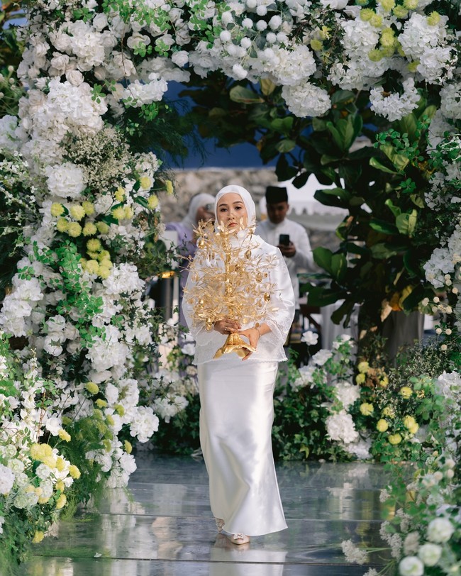 Erra menerima mas kawin unik berupa pohon bunga emas dengan 102 gram atau setara dengan 24 dinar emas. Pihak mempelai pria juga memberikan seserahan cincin berlian senilai sekitar RM80.000 atau sekitar Rp 325 juta, sejumlah aksesori, dan rangkaian parfum. Foto: Dok. Instagram Erra Fazira