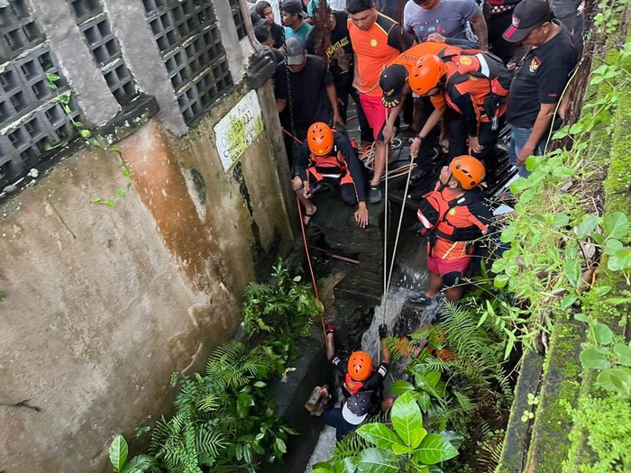 Proses evakuasi WNA yang terseret arus banjir dan jasadnya tersangkut di gorong-gorong Desa Tibubeneng, Kuta Utara, Badung, Bali, Minggu (14/12/2025). (Foto: Dok. Polres Badung)