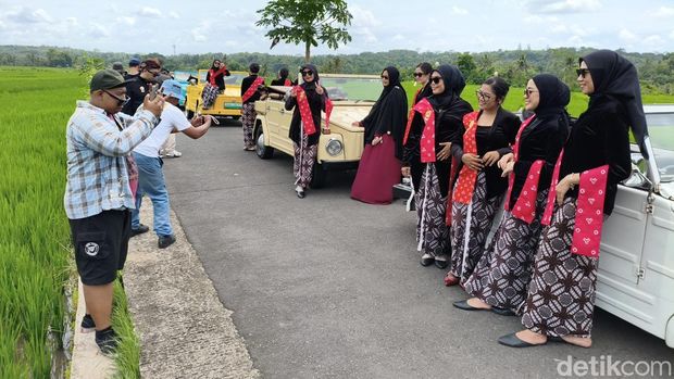 Wisatawan saat berfoto dengan busana Jawa dan latar belakang persawahan di Nanggulan, Kulon Progo, Sabtu (13/12/2025).