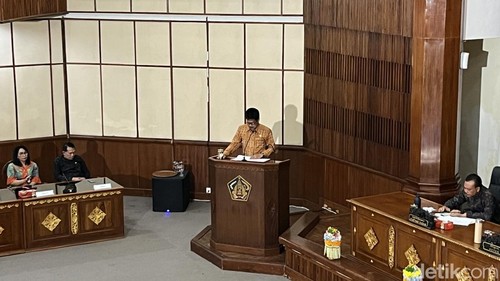 Anggota Fraksi Golkar DPRD Bali, I Nyoman Wirya menyampaikan pandangan umum fraksi terhadap dua raperda saat rapat paripurna DPRD Bali, Senin (15/12/2025)