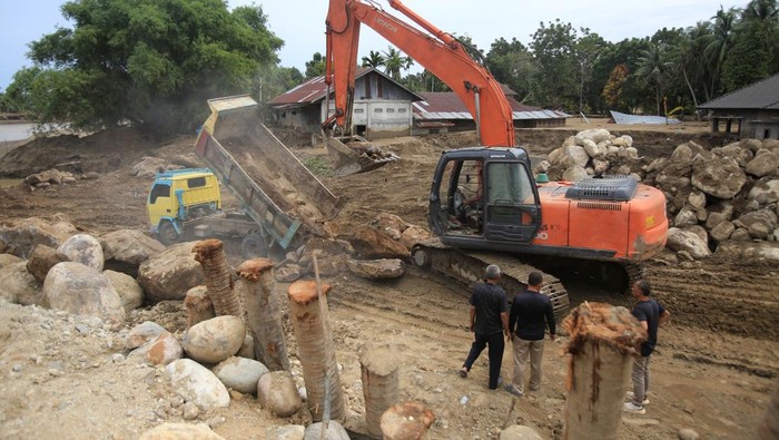 Pekerja menggunakan alat berat membangun tanggul sungai pascabanjir bandang di kabupaten Pidie Jaya, Aceh, Minggu (14/12/2025).  Pemerintah terus berupaya mempercepat pemulihan infrastruktur yang rusak pascabencana banjir badang di Sumatera Barat, Sumatera Utara dan Aceh. ANTARA FOTO/Ampelsa/agr