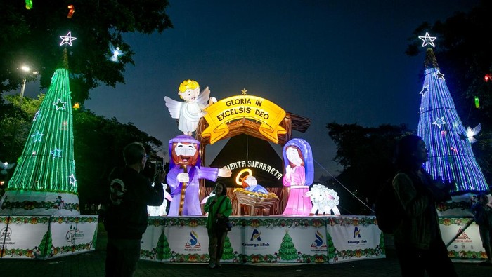 Warga berfoto dengan latar belakang dekorasi hiasan lampion bertema Natal di kawasan Balai Kota, Solo, Jawa Tengah, Senin (15/12/2025). Lampion Natal tersebut dipasang untuk menyambut Hari Natal 2025 sekaligus upaya manarik kunjungan wisatawan hingga mampu berdampak positif bagi ekonomi Kota Solo. ANTARA FOTO/Mohammad Ayudha