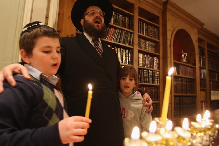 BERLIN - DECEMBER 10:  Orthodox Jewish Rabbi Yehuda Teichtal and two of his children, David, 11, and Chana, 9, sing after lighting a menorah at their home on the second to last evening of Hannukah December 10, 2007 in Berlin, Germany. Berlin's Jewish community has grown sharply in recent years with the arrival of thousands of Jews from the former Soviet Union. Teichtal arrived in Berlin 11 years ago and both of his children have grown up in the city, which today has eight functioning synagogues and a Jewish population that Teichtal estimates at 40,000.  (Photo by Sean Gallup/Getty Images)