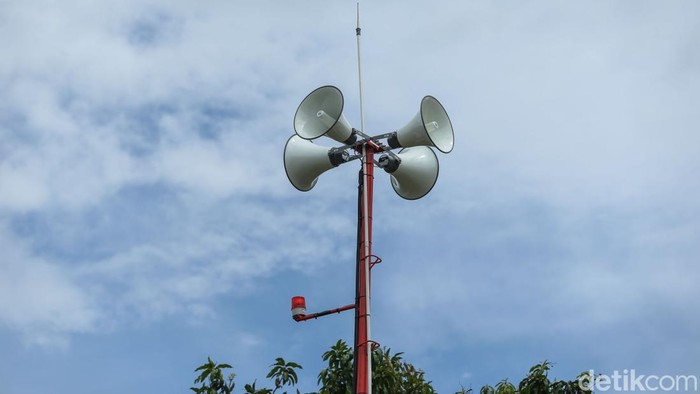 Pengendara melintas di depan mesin Early Warning System (EWS) banjir di Bekasi, Senin (15/12/2025). Dipasangnya early warning system (EWS) banjir di sejumlah titik rawan ini untuk memperkuat mitigasi bencana saat musim hujan. Perangkat peringatan dini ini tersebar di wilayah yang berada di sepanjang aliran sungai dan kawasan permukiman yang kerap terdampak luapan air, khususnya di Daerah Aliran Sungai (DAS) Kali Bekasi dan sekitarnya.