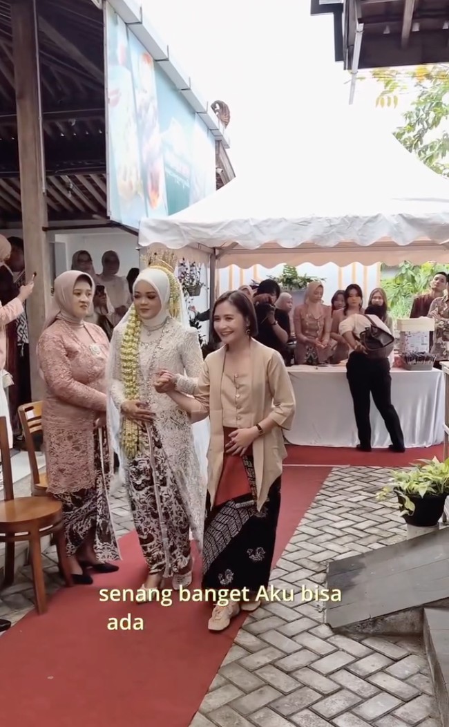 Di acara tersebut Prilly sekaligus iminta menjadi pengiring pengantin. Terlihat Prilly yang mengenakan busana bernuansa coklat menggandeng pengantin wanita memasuki lokasi acara. Foto: Instagram/@prillylatuconsina96
