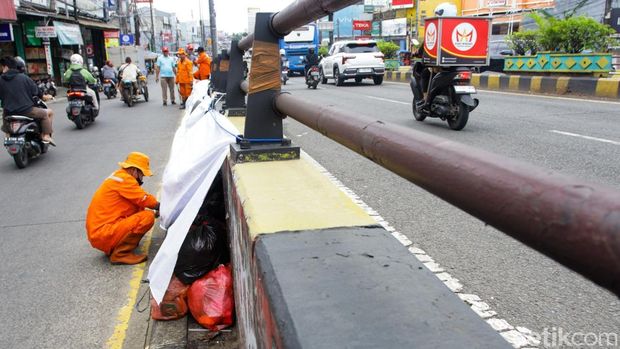 Sampah di Ciputat Menggunung, Ditutup Terpal Sementara Sejumlah warga merapikan tumpukan sampah di kawasan Ciputat, Tangerang Selatan, Banten, Senin (15/12/2025).