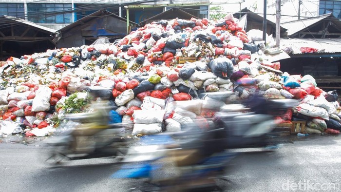 Sejumlah warga merapikan tumpukan sampah di kawasan Ciputat, Tangerang Selatan, Banten, Senin (15/12/2025).