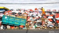 Petugas tengah melakukan penyusunan tumpukan sampah di Jalan Jombang Raya, Ciputat, Tangerang Selatan, Senin (15/12/2025).