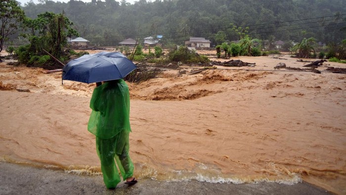 Tim SAR memandu warga menyeberangi air menggunakan tali di kawasan Batu Busuk, Pauh, Padang, Sumatera Barat, Minggu (14/12/2025). Air sungai di permukiman terdampak banjir bandang tersebut kembali meluap dan membuat sejumlah warga dievakuasi ke tempat yang lebih aman. ANTARA FOTO/Iggoy el Fitra/agr