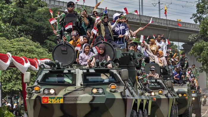 Prajurit TNI Angkatan Darat mendampingi warga menaiki kendaraan taktis (rantis) panser Anoa usai peringatan Hari Juang TNI AD di di Lapangan Manunggal Brigif 15/Kujang II, Kota Cimahi, Jawa Barat, Senin (15/12/2025). Demonstrasi militer dan parade serta pameran alat utama sistem senjata (alutsista) tersebut digelar dalam rangka memeriahkan peringatan Hari Juang TNI AD yang mengusung tema TNI AD manunggal dengan rakyat untuk Indonesia bersatu, berdaulat, sejahtera dan maju. ANTARA FOTO/Abdan Syakura/nz