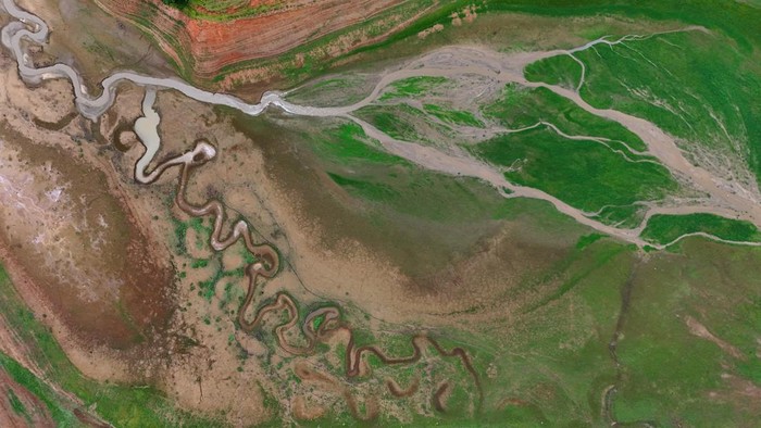 A drone view shows dried channels and green patches on the exposed surface of Jaguari dam during its lowest level in a decade, according to data from Brazilian water and waste management company Sabesp, in Joanopolis in the state of Sao Paulo, Brazil, December 15, 2025. REUTERS/Jorge Silva
