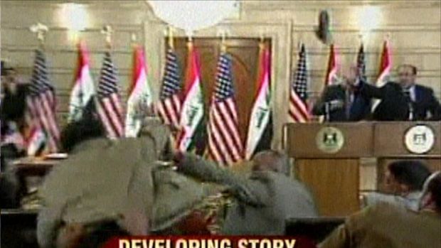 Cuplikan dari video siaran langsung, yang diperoleh CNN, menunjukkan Presiden AS George W. Bush (latar belakang kiri), menunduk saat seorang jurnalis melemparkan dua sepatu ke arahnya pada 14 Desember 2008 dalam kunjungan perpisahan Bush ke Irak. (Photo by CNN / AFP/File Foto)