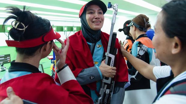 BANGKOK, THAILAND - 2025/12/13: Dewi Laila Mubarokha (C) from Indonesia celebrates a gold medal during Women 10m Air Rifle Individual final round at SAT shooting range. (Photo by Peerapon Boonyakiat/SOPA Images/LightRocket via Getty Images)