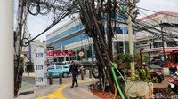 Kabel-kabel terlihat menempel pada tiang yang tidak kokoh di kawasan Tebet. Situasi ini dinilai rawan, terutama saat hujan dan angin kencang.