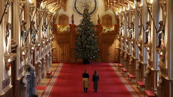 A staff member arranges garlands in the Grand Staircase in Windsor Castle during a media preview of the festive decorations at the royal residence, in Windsor, Britain, November 27, 2025. REUTERS/Isabel Infantes