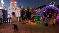 Suasana malam di sekitar rumah tampak semarak dengan cahaya Natal yang menyala. Selain hiburan gratis, pengunjung juga diajak berdonasi untuk badan amal lokal. Foto: REUTERS/Esa Alexander
