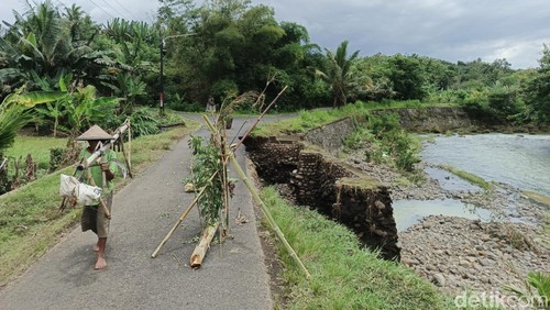 Kondisi jebolnya senderan jalan sepanjang 20 meter di Link Pangkung Manggis, Kelurahan Baler Bale Agung , Kecamatan Negara, Jembrana, Selasa (16/12/2025).