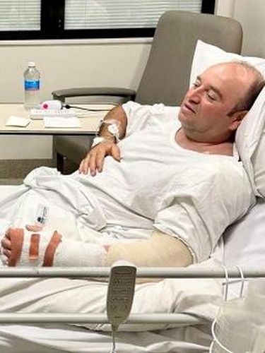 This handout photo taken and received from the NSW Premier's Department on December 15, 2025 shows New South Wales Premier Chris Minns (L) talking with Ahmed Al Ahmed, the man who tackled and disarmed one of the Bondi beach attackers, at St George Hospital in Sydney. Australia's leaders agreed on December 15 to tougher gun laws after the country's worst mass shooting in almost three decades saw a father and son open fire on a Jewish festival at Bondi Beach, killing 15 people including a child. (Photo by Handout / NSW Premier's Department / AFP) / RESTRICTED TO EDITORIAL USE - MANDATORY CREDIT 