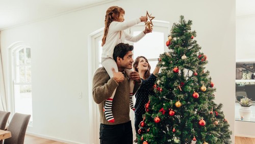 Ilustrasi mendekorasi pohon Natal.