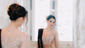 Potret close-up Sarah di balik pantulan kaca menonjolkan riasan soft glam dan kebaya Bali bernuansa nude. Foto: Instagram Sarah Menzel