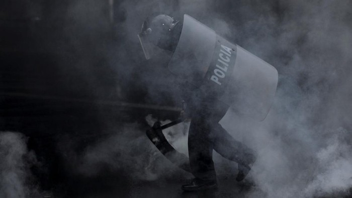 A demonstrator pours fuel on a barricade of burning tires as part of a protest nearly two weeks after the presidential election, as the vote remains stalled amid uncounted ballots, fraud accusations and electoral system failures, in Tegucigalpa, Honduras, December 15, 2025. REUTERS/Fredy Rodriguez