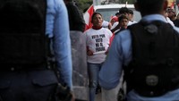 Seorang demonstran dari partai LIBRE menyuarakan penolakan terhadap hasil pemilu yang dinilai tidak adil. Mereka menuding adanya intervensi dan ancaman terhadap demokrasi Honduras. Aparat keamanan berjaga di sekitar lokasi penghitungan ulang suara yang tertunda akibat protes. Petugas pemilu belum dapat memulai penghitungan manual sekitar 15 persen lembar suara bermasalah. REUTERS/Fredy Rodriguez