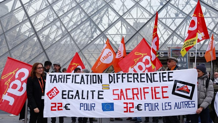 Louvre museum employees on strike gather in front the glass Pyramid to protest their working conditions at the museum, the state of the museum's buildings and staffing issues, two months after a spectacular heist which saw thieves make off with jewels in broad daylight, outside the Louvre Museum in Paris, France, December 15, 2025. REUTERS/Benoit Tessier