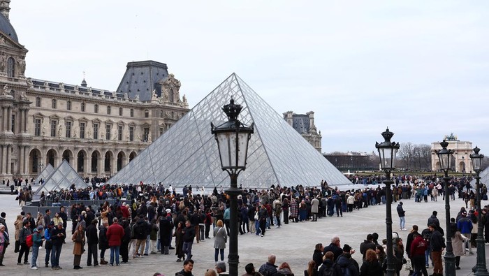 Louvre museum employees on strike gather in front the glass Pyramid to protest their working conditions at the museum, the state of the museum's buildings and staffing issues, two months after a spectacular heist which saw thieves make off with jewels in broad daylight, outside the Louvre Museum in Paris, France, December 15, 2025. REUTERS/Benoit Tessier