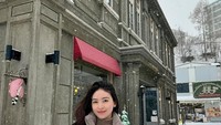 Begini pose cantik Natasha ketika merayakan Natal di Hokkaido, Jepang. Di sana, Natasha jajan manisan buah berlapis gula atau tanghulu. Foto: Instagram @natashawilona12