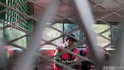 Dua tersangka kasus penyelewengan bantuan rumah subsidi berada di dalam mobil tahanan Kejati Bali untuk dibawa ke Lapas Kelas IIA Kerobokan, Badung, Rabu (17/12/2025). (Foto: Ahmad Firizqi Irwan/detikBali)