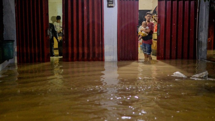 Warga menerobos banjir di Jl. Letnan Jendral R. Suprapto, Kelurahan Kubangsari, Kota Cilegon, Banten, Selasa (16/12/2025). Tingginya intensitas hujan sejak pagi hari menyebabkan kawasan tersebut serta jalur kereta api barang terendam banjir dengan ketinggian sekitar 60 cm hingga lebih dari 100 cm. ANTARA FOTO/Muhammad Bagus Khoirunas