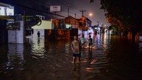 Warga menerobos banjir di Jalan Letnan Jendral R. Suprapto, Kelurahan Kubangsari, Kota Cilegon, Banten, Selasa (16/12/2025). ANTARA FOTO/Muhammad Bagus Khoirunas