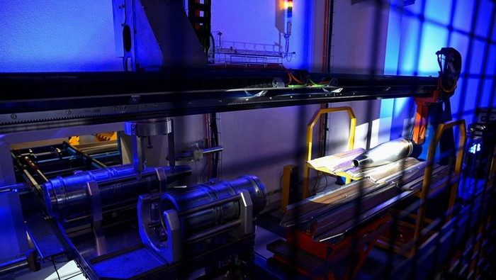 Employees operate a new filling line for artillery ammunition, known as the 