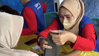 Petugas kesehatan dengan telaten memeriksa tekanan darah warga untuk memastikan kondisi kesehatan mereka terpantau secara berkala. (FOTO: Khadijah Nur Azizah/detikHealth)