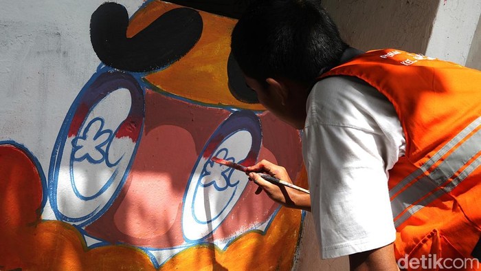 Petugas Penanganan Prasarana dan Sarana Umum (PPSU) Kelurahan Kebayoran Lama Utara (KLU) mengecat mural pada sebuah posko organisasi kemasyarakatan (ormas) yang terbengkalai di pertigaan Tanah Kusir, Jakarta Selatan, Rabu (17/12/2005). Kegiatan tersebut dilakukan untuk memperindah lingkungan sekaligus mencegah kawasan terlihat kumuh.