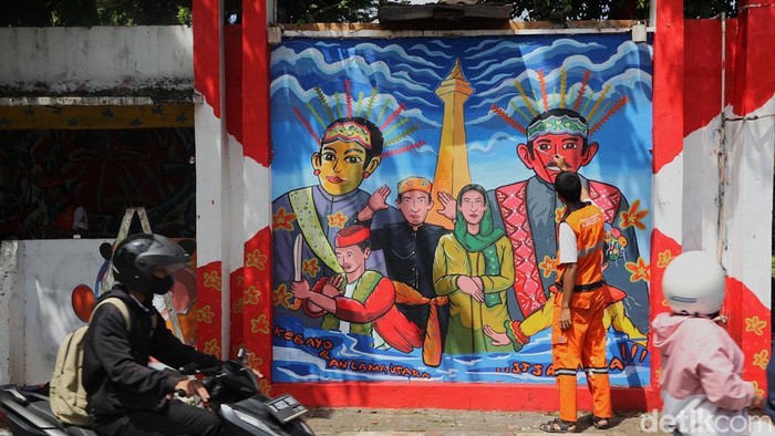Petugas Penanganan Prasarana dan Sarana Umum (PPSU) Kelurahan Kebayoran Lama Utara (KLU) mengecat mural pada sebuah posko organisasi kemasyarakatan (ormas) yang terbengkalai di pertigaan Tanah Kusir, Jakarta Selatan, Rabu (17/12/2005). Kegiatan tersebut dilakukan untuk memperindah lingkungan sekaligus mencegah kawasan terlihat kumuh.