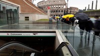 Para pejalan kaki berjalan melewati pintu masuk stasiun metro Colosseum yang baru di Roma, Italia. Setelah bertahun-tahun tertunda dan mengalami pembengkakan anggaran, Roma pada hari Selasa (16/12) waktu setempat, membuka dua stasiun Metro C baru – Colosseo/Fori Imperiali dan Porta Metronia – di jantung kota bersejarah. REUTERS/Remo Casilli