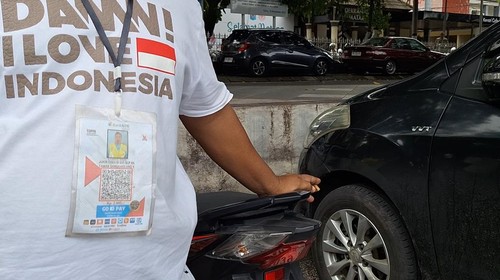 Salah satu jukir di Taman Sangkareang, Mataram, menunjukkan pembayaran parkir melalui QRIS, Selasa (16/12/2025). (Nathea Citra/detikBali)