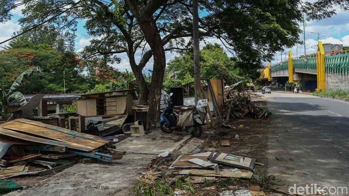 Warga beraktivitas di samping runtuhan bangunan liar di sepanjang bantaran Kalimalang, Cikarang, Kabupaten Bekasi, Rabu (17/12/2025).