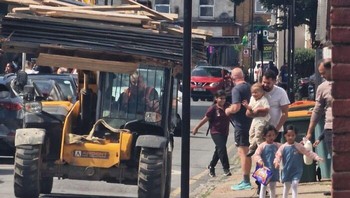 Alat berat membawa muatan panjang melintas dekat pejalan kaki. Kayu yang menjulur tanpa pengaman mengancam keselamatan orang-orang di trotoar. Foto: Boredpanda