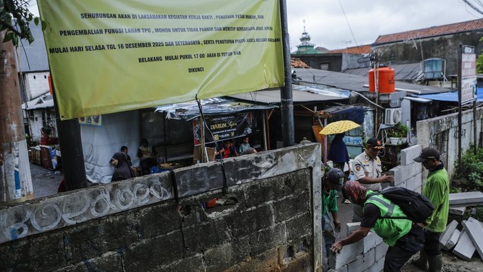Petugas membawa barang bongkaran lapak usaha di TPU Kober Rawa Bunga, Jatinegara, Jakarta, Kamis (18/12/2025). Pemprov DKI Jakarta akan mengembalikan fungsi lahan di TPU Kober Rawa Bunga yang sebelumnya digunakan sebagai tempat usaha menjadi pemakaman yang dapat menampung 450 petak makam. ANTARA FOTO/Asprilla Dwi Adha