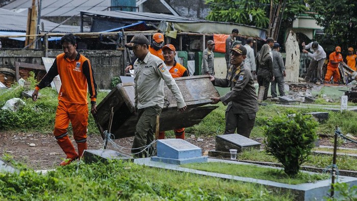 Petugas membawa barang bongkaran lapak usaha di TPU Kober Rawa Bunga, Jatinegara, Jakarta, Kamis (18/12/2025). Pemprov DKI Jakarta akan mengembalikan fungsi lahan di TPU Kober Rawa Bunga yang sebelumnya digunakan sebagai tempat usaha menjadi pemakaman yang dapat menampung 450 petak makam. ANTARA FOTO/Asprilla Dwi Adha