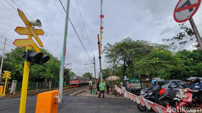 Para pekerja menyelesaikan fasilitas palang perlintasan kereta api di kawasan Simprug, Jakarta, Kamis (18/12/2025).  PT KAI membangun palang perlintasan kereta api baru di beberapa titik antara Stasiun Kebayoran Baru hingga Stasiun Tanah Abang. Sebelumnya, di titik perlintasan tersebut belum dibangun palang pintu perlintasan sehingga pengendara yang melintas harus waspada. Warga sekitar kerap memanfaatkan ketiadaan palang perlintasan dengan membantu membuat palang perlintasan manual dengan menarik uang seikhlasnya kepada pengendara.