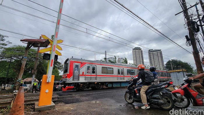 Para pekerja menyelesaikan fasilitas palang perlintasan kereta api di kawasan Simprug, Jakarta, Kamis (18/12/2025).  PT KAI membangun palang perlintasan kereta api baru di beberapa titik antara Stasiun Kebayoran Baru hingga Stasiun Tanah Abang. Sebel