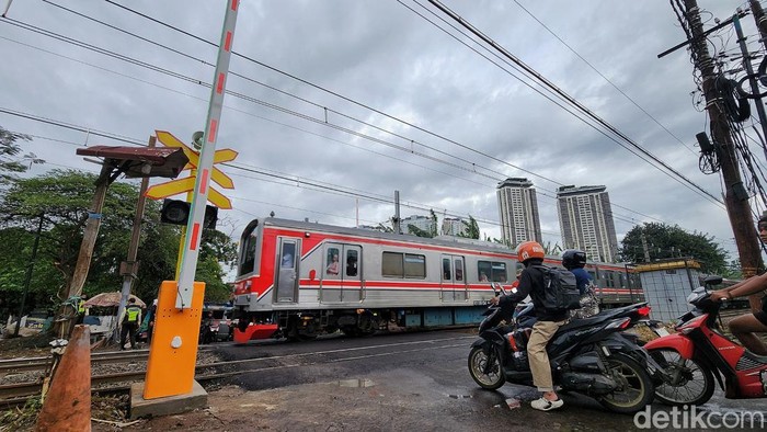 Para pekerja menyelesaikan fasilitas palang perlintasan kereta api di kawasan Simprug, Jakarta, Kamis (18/12/2025).  PT KAI membangun palang perlintasan kereta api baru di beberapa titik antara Stasiun Kebayoran Baru hingga Stasiun Tanah Abang. Sebelumnya, di titik perlintasan tersebut belum dibangun palang pintu perlintasan sehingga pengendara yang melintas harus waspada. Warga sekitar kerap memanfaatkan ketiadaan palang perlintasan dengan membantu membuat palang perlintasan manual dengan menarik uang seikhlasnya kepada pengendara.