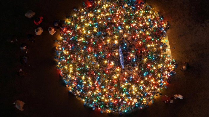 A drone view shows people gathering around the 5th Annual Stonington Lobster Trap Tree, made of 460 lobster traps, in Stonington, Connecticut, U.S., December 17, 2025.   REUTERS/Brian Snyder