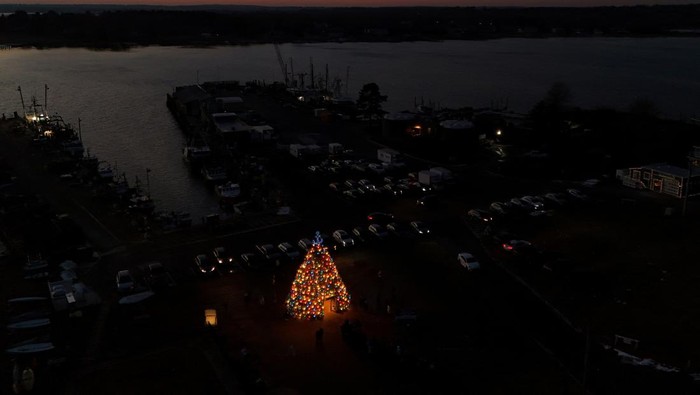 A drone view shows people gathering around the 5th Annual Stonington Lobster Trap Tree, made of 460 lobster traps, in Stonington, Connecticut, U.S., December 17, 2025.   REUTERS/Brian Snyder