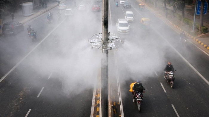 Pemerintah New Delhi memasang sistem penyemprotan kabut di sejumlah ruas jalan utama sebagai upaya mengendalikan polusi udara yang kembali memburuk, Kamis (18/12/2025). Sistem tersebut menyemprotkan kabut air ke udara untuk menurunkan kadar partikel polutan, terutama di kawasan dengan lalu lintas padat. REUTERS/Adnan Abidi