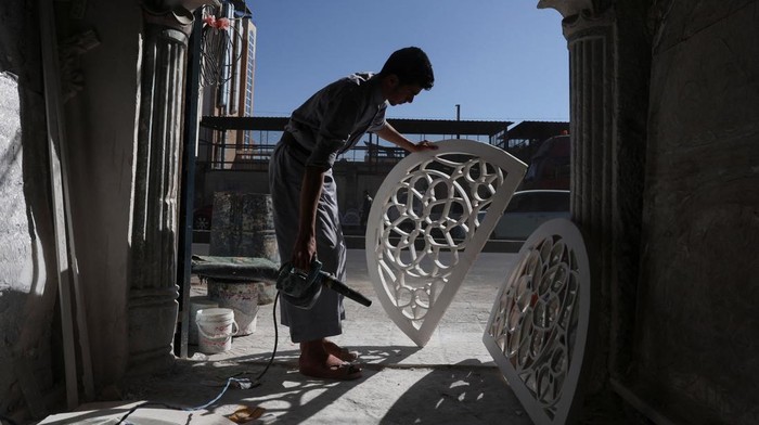 A man walks in a room adorned with Qamarias, a traditional arched plasterwork window, in Sanaa, Yemen, December 13, 2025. Such traditional window designs become increasingly rare, often replaced by modern construction techniques. REUTERS/Khaled Abdullah REFILE - CORRECTING DATE FROM 